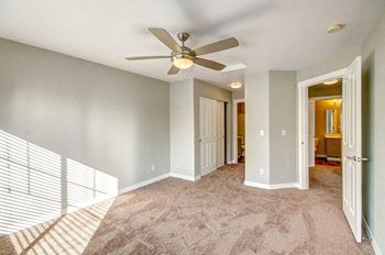 an empty living room with a ceiling fan